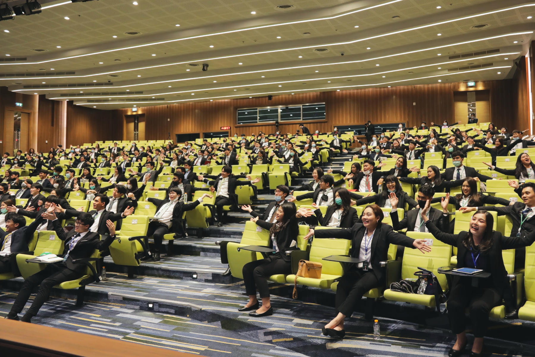 Audience playing a workshop activity in an auditorium